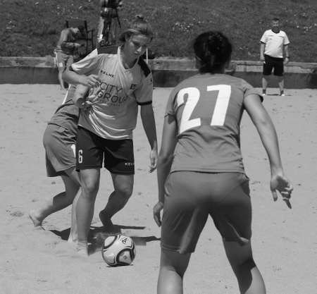 ODESSA, UKRAINE July 8, 2021: Ukrainian Beach Soccer Women's Cup. The girl's footballers are desperately playing beach soccer on sand of sea city beach on a hot sunny day. Women's soccer on sandのeditorial素材