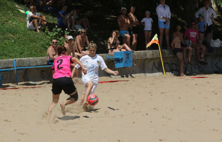 ODESSA, UKRAINE July 8, 2021: Ukrainian Beach Soccer Women's Cup. The girl's footballers are desperately playing beach soccer on sand of sea city beach on a hot sunny day. Women's soccer on sandのeditorial素材