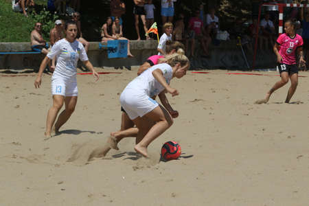 ODESSA, UKRAINE July 8, 2021: Ukrainian Beach Soccer Women's Cup. The girl's footballers are desperately playing beach soccer on sand of sea city beach on a hot sunny day. Women's soccer on sandのeditorial素材