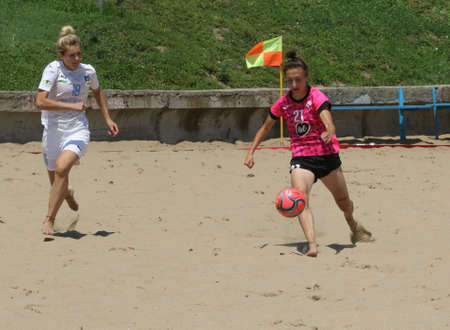 ODESSA, UKRAINE July 8, 2021: Ukrainian Beach Soccer Women's Cup. The girl's footballers are desperately playing beach soccer on sand of sea city beach on a hot sunny day. Women's soccer on sandのeditorial素材