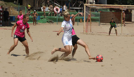 ODESSA, UKRAINE July 8, 2021: Ukrainian Beach Soccer Women's Cup. The girl's footballers are desperately playing beach soccer on sand of sea city beach on a hot sunny day. Women's soccer on sandのeditorial素材