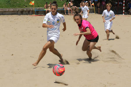 ODESSA, UKRAINE July 8, 2021: Ukrainian Beach Soccer Women's Cup. The girl's footballers are desperately playing beach soccer on sand of sea city beach on a hot sunny day. Women's soccer on sandのeditorial素材
