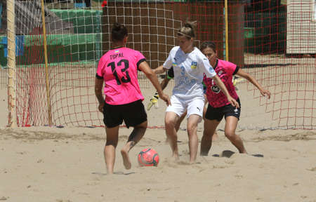 ODESSA, UKRAINE July 8, 2021: Ukrainian Beach Soccer Women's Cup. The girl's footballers are desperately playing beach soccer on sand of sea city beach on a hot sunny day. Women's soccer on sandのeditorial素材