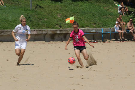 ODESSA, UKRAINE July 8, 2021: Ukrainian Beach Soccer Women's Cup. The girl's footballers are desperately playing beach soccer on sand of sea city beach on a hot sunny day. Women's soccer on sandのeditorial素材