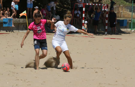 ODESSA, UKRAINE July 8, 2021: Ukrainian Beach Soccer Women's Cup. The girl's footballers are desperately playing beach soccer on sand of sea city beach on a hot sunny day. Women's soccer on sandのeditorial素材