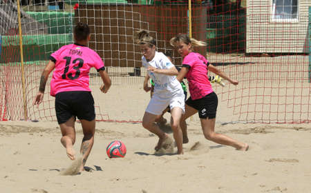 ODESSA, UKRAINE July 8, 2021: Ukrainian Beach Soccer Women's Cup. The girl's footballers are desperately playing beach soccer on sand of sea city beach on a hot sunny day. Women's soccer on sandのeditorial素材