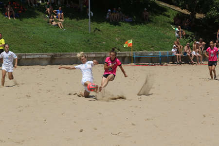 ODESSA, UKRAINE July 8, 2021: Ukrainian Beach Soccer Women's Cup. The girl's footballers are desperately playing beach soccer on sand of sea city beach on a hot sunny day. Women's soccer on sandのeditorial素材