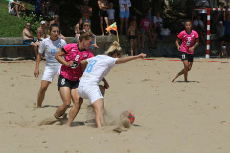 ODESSA, UKRAINE July 8, 2021: Ukrainian Beach Soccer Women's Cup. The girl's footballers are desperately playing beach soccer on sand of sea city beach on a hot sunny day. Women's soccer on sandのeditorial素材