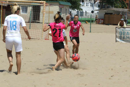 ODESSA, UKRAINE July 8, 2021: Ukrainian Beach Soccer Women's Cup. The girl's footballers are desperately playing beach soccer on sand of sea city beach on a hot sunny day. Women's soccer on sandのeditorial素材