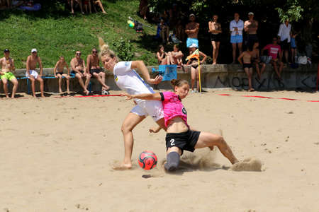 ODESSA, UKRAINE July 8, 2021: Ukrainian Beach Soccer Women's Cup. The girl's footballers are desperately playing beach soccer on sand of sea city beach on a hot sunny day. Women's soccer on sandのeditorial素材