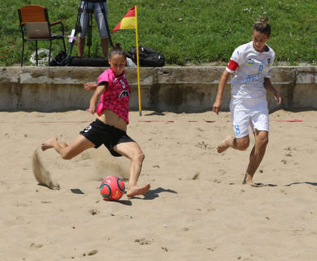 ODESSA, UKRAINE July 8, 2021: Ukrainian Beach Soccer Women's Cup. The girl's footballers are desperately playing beach soccer on sand of sea city beach on a hot sunny day. Women's soccer on sandのeditorial素材