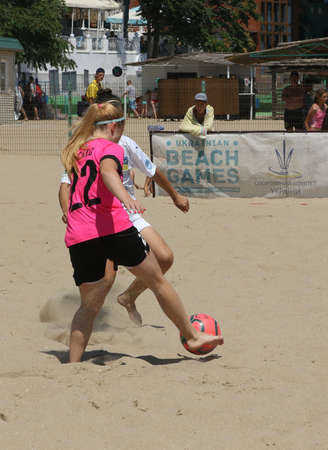 ODESSA, UKRAINE July 8, 2021: Ukrainian Beach Soccer Women's Cup. The girl's footballers are desperately playing beach soccer on sand of sea city beach on a hot sunny day. Women's soccer on sandのeditorial素材