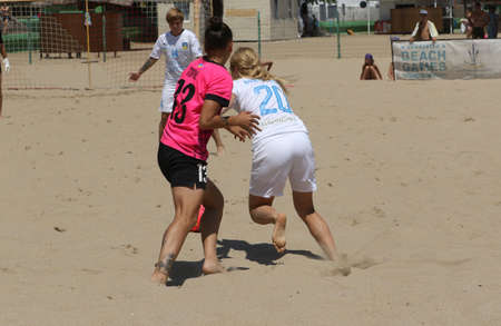 ODESSA, UKRAINE July 8, 2021: Ukrainian Beach Soccer Women's Cup. The girl's footballers are desperately playing beach soccer on sand of sea city beach on a hot sunny day. Women's soccer on sandのeditorial素材