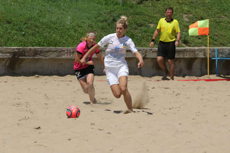ODESSA, UKRAINE July 8, 2021: Ukrainian Beach Soccer Women's Cup. The girl's footballers are desperately playing beach soccer on sand of sea city beach on a hot sunny day. Women's soccer on sandのeditorial素材