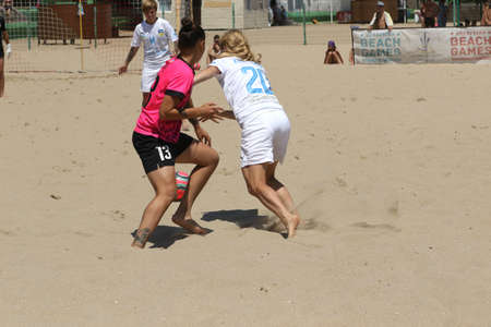 ODESSA, UKRAINE July 8, 2021: Ukrainian Beach Soccer Women's Cup. The girl's footballers are desperately playing beach soccer on sand of sea city beach on a hot sunny day. Women's soccer on sandのeditorial素材