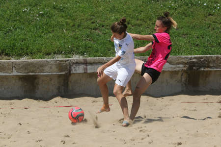 ODESSA, UKRAINE July 8, 2021: Ukrainian Beach Soccer Women's Cup. The girl's footballers are desperately playing beach soccer on sand of sea city beach on a hot sunny day. Women's soccer on sandのeditorial素材