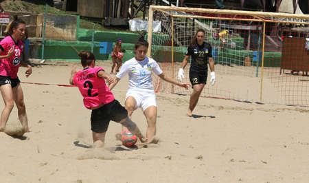ODESSA, UKRAINE July 8, 2021: Ukrainian Beach Soccer Women's Cup. The girl's footballers are desperately playing beach soccer on sand of sea city beach on a hot sunny day. Women's soccer on sandのeditorial素材