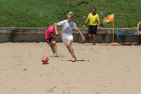 ODESSA, UKRAINE July 8, 2021: Ukrainian Beach Soccer Women's Cup. The girl's footballers are desperately playing beach soccer on sand of sea city beach on a hot sunny day. Women's soccer on sandのeditorial素材