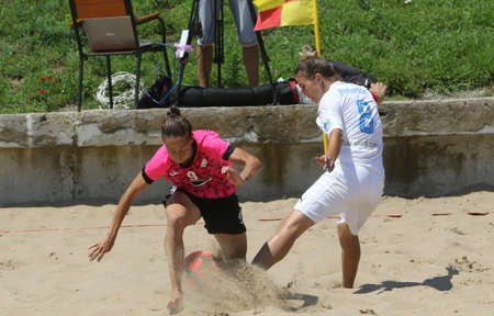 ODESSA, UKRAINE July 8, 2021: Ukrainian Beach Soccer Women's Cup. The girl's footballers are desperately playing beach soccer on sand of sea city beach on a hot sunny day. Women's soccer on sandのeditorial素材