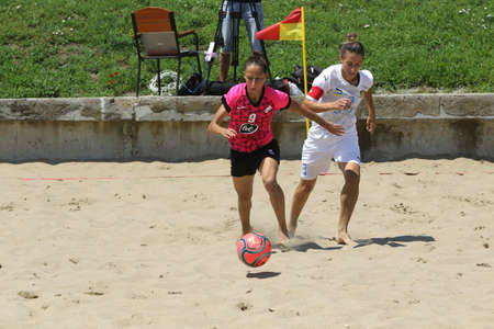 ODESSA, UKRAINE July 8, 2021: Ukrainian Beach Soccer Women's Cup. The girl's footballers are desperately playing beach soccer on sand of sea city beach on a hot sunny day. Women's soccer on sandのeditorial素材
