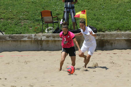 ODESSA, UKRAINE July 8, 2021: Ukrainian Beach Soccer Women's Cup. The girl's footballers are desperately playing beach soccer on sand of sea city beach on a hot sunny day. Women's soccer on sandのeditorial素材