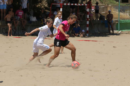 ODESSA, UKRAINE July 8, 2021: Ukrainian Beach Soccer Women's Cup. The girl's footballers are desperately playing beach soccer on sand of sea city beach on a hot sunny day. Women's soccer on sandのeditorial素材