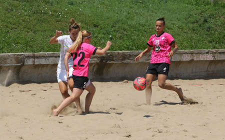 ODESSA, UKRAINE July 8, 2021: Ukrainian Beach Soccer Women's Cup. The girl's footballers are desperately playing beach soccer on sand of sea city beach on a hot sunny day. Women's soccer on sandのeditorial素材