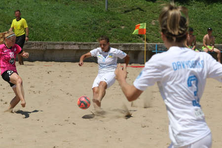 ODESSA, UKRAINE July 8, 2021: Ukrainian Beach Soccer Women's Cup. The girl's footballers are desperately playing beach soccer on sand of sea city beach on a hot sunny day. Women's soccer on sandのeditorial素材