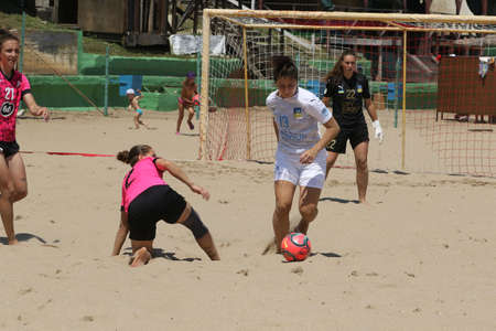 ODESSA, UKRAINE July 8, 2021: Ukrainian Beach Soccer Women's Cup. The girl's footballers are desperately playing beach soccer on sand of sea city beach on a hot sunny day. Women's soccer on sandのeditorial素材