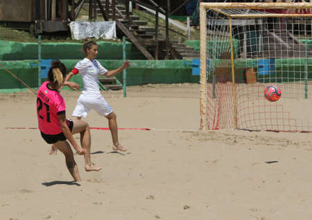ODESSA, UKRAINE July 8, 2021: Ukrainian Beach Soccer Women's Cup. The girl's footballers are desperately playing beach soccer on sand of sea city beach on a hot sunny day. Women's soccer on sandのeditorial素材