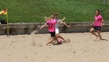 ODESSA, UKRAINE July 8, 2021: Ukrainian Beach Soccer Women's Cup. The girl's footballers are desperately playing beach soccer on sand of sea city beach on a hot sunny day. Women's soccer on sandのeditorial素材