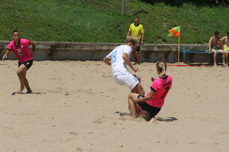 ODESSA, UKRAINE July 8, 2021: Ukrainian Beach Soccer Women's Cup. The girl's footballers are desperately playing beach soccer on sand of sea city beach on a hot sunny day. Women's soccer on sandのeditorial素材
