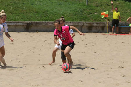 ODESSA, UKRAINE July 8, 2021: Ukrainian Beach Soccer Women's Cup. The girl's footballers are desperately playing beach soccer on sand of sea city beach on a hot sunny day. Women's soccer on sandのeditorial素材
