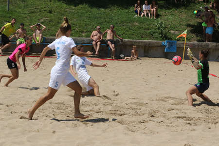 ODESSA, UKRAINE July 8, 2021: Ukrainian Beach Soccer Women's Cup. The girl's footballers are desperately playing beach soccer on sand of sea city beach on a hot sunny day. Women's soccer on sandのeditorial素材