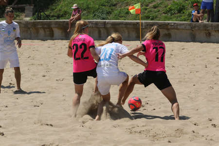 ODESSA, UKRAINE July 8, 2021: Ukrainian Beach Soccer Women's Cup. The girl's footballers are desperately playing beach soccer on sand of sea city beach on a hot sunny day. Women's soccer on sandのeditorial素材