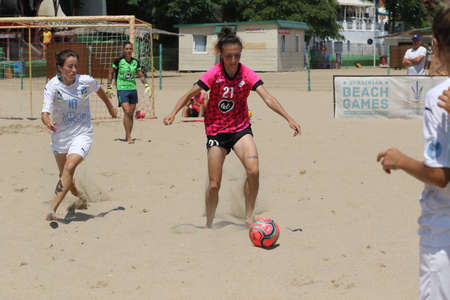 ODESSA, UKRAINE July 8, 2021: Ukrainian Beach Soccer Women's Cup. The girl's footballers are desperately playing beach soccer on sand of sea city beach on a hot sunny day. Women's soccer on sandのeditorial素材