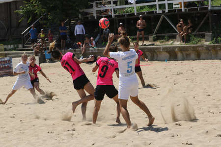 ODESSA, UKRAINE July 8, 2021: Ukrainian Beach Soccer Women's Cup. The girl's footballers are desperately playing beach soccer on sand of sea city beach on a hot sunny day. Women's soccer on sandのeditorial素材