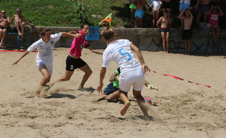 ODESSA, UKRAINE July 8, 2021: Ukrainian Beach Soccer Women's Cup. The girl's footballers are desperately playing beach soccer on sand of sea city beach on a hot sunny day. Women's soccer on sandのeditorial素材
