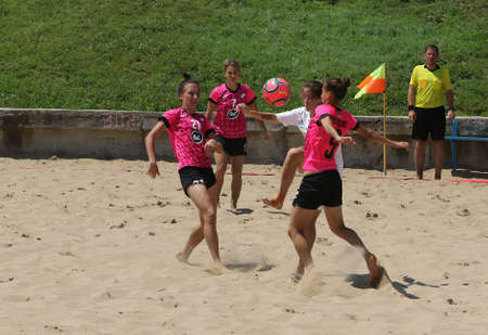ODESSA, UKRAINE July 8, 2021: Ukrainian Beach Soccer Women's Cup. The girl's footballers are desperately playing beach soccer on sand of sea city beach on a hot sunny day. Women's soccer on sandのeditorial素材