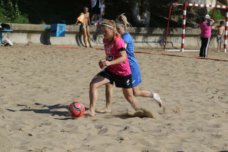 ODESSA, UKRAINE July 8, 2021: Ukrainian Beach Soccer Women's Cup. The girl's footballers are desperately playing beach soccer on sand of sea city beach on a hot sunny day. Women's soccer on sandのeditorial素材