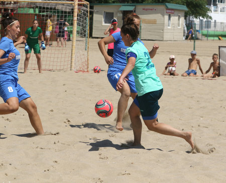 ODESSA, UKRAINE July 8, 2021: Ukrainian Beach Soccer Women's Cup. The girl's footballers are desperately playing beach soccer on sand of sea city beach on a hot sunny day. Women's soccer on sandのeditorial素材