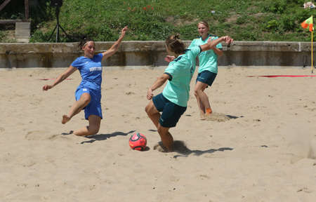 ODESSA, UKRAINE July 8, 2021: Ukrainian Beach Soccer Women's Cup. The girl's footballers are desperately playing beach soccer on sand of sea city beach on a hot sunny day. Women's soccer on sandのeditorial素材