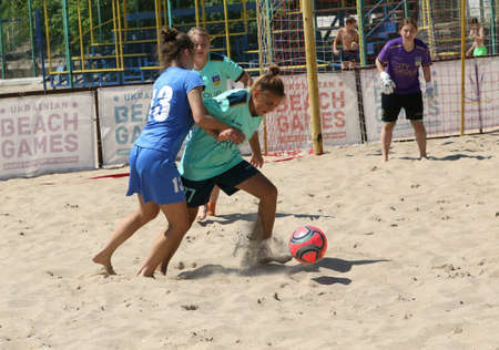 ODESSA, UKRAINE July 8, 2021: Ukrainian Beach Soccer Women's Cup. The girl's footballers are desperately playing beach soccer on sand of sea city beach on a hot sunny day. Women's soccer on sandのeditorial素材