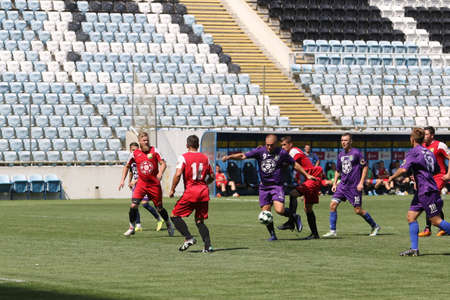 ODESSA, UKRAINE - aug 24, 2021: Football. Traditional Cup of Ukraine among ATO veterans. Veterans play football on green lawn of stadium. Game moment of football fight for cup. Vivid emotions of gameのeditorial素材