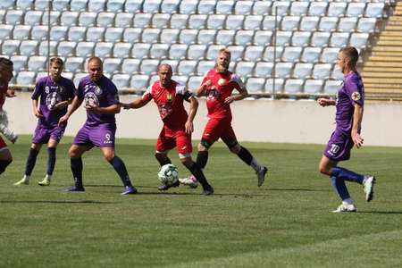 ODESSA, UKRAINE - aug 24, 2021: Football. Traditional Cup of Ukraine among ATO veterans. Veterans play football on green lawn of stadium. Game moment of football fight for cup. Vivid emotions of gameのeditorial素材