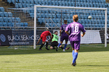 ODESSA, UKRAINE - aug 24, 2021: Football. Traditional Cup of Ukraine among ATO veterans. Veterans play football on green lawn of stadium. Game moment of football fight for cup. Vivid emotions of gameのeditorial素材