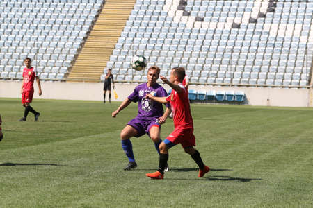 ODESSA, UKRAINE - aug 24, 2021: Football. Traditional Cup of Ukraine among ATO veterans. Veterans play football on green lawn of stadium. Game moment of football fight for cup. Vivid emotions of gameのeditorial素材