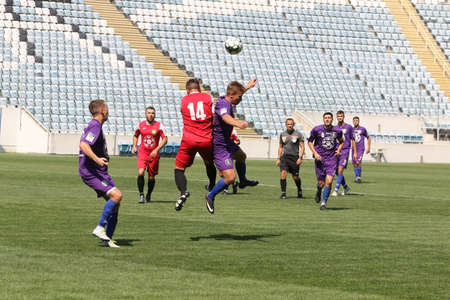 ODESSA, UKRAINE - aug 24, 2021: Football. Traditional Cup of Ukraine among ATO veterans. Veterans play football on green lawn of stadium. Game moment of football fight for cup. Vivid emotions of gameのeditorial素材