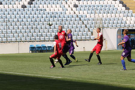 ODESSA, UKRAINE - aug 24, 2021: Football. Traditional Cup of Ukraine among ATO veterans. Veterans play football on green lawn of stadium. Game moment of football fight for cup. Vivid emotions of gameのeditorial素材