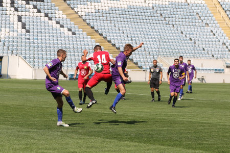 ODESSA, UKRAINE - aug 24, 2021: Football. Traditional Cup of Ukraine among ATO veterans. Veterans play football on green lawn of stadium. Game moment of football fight for cup. Vivid emotions of gameのeditorial素材